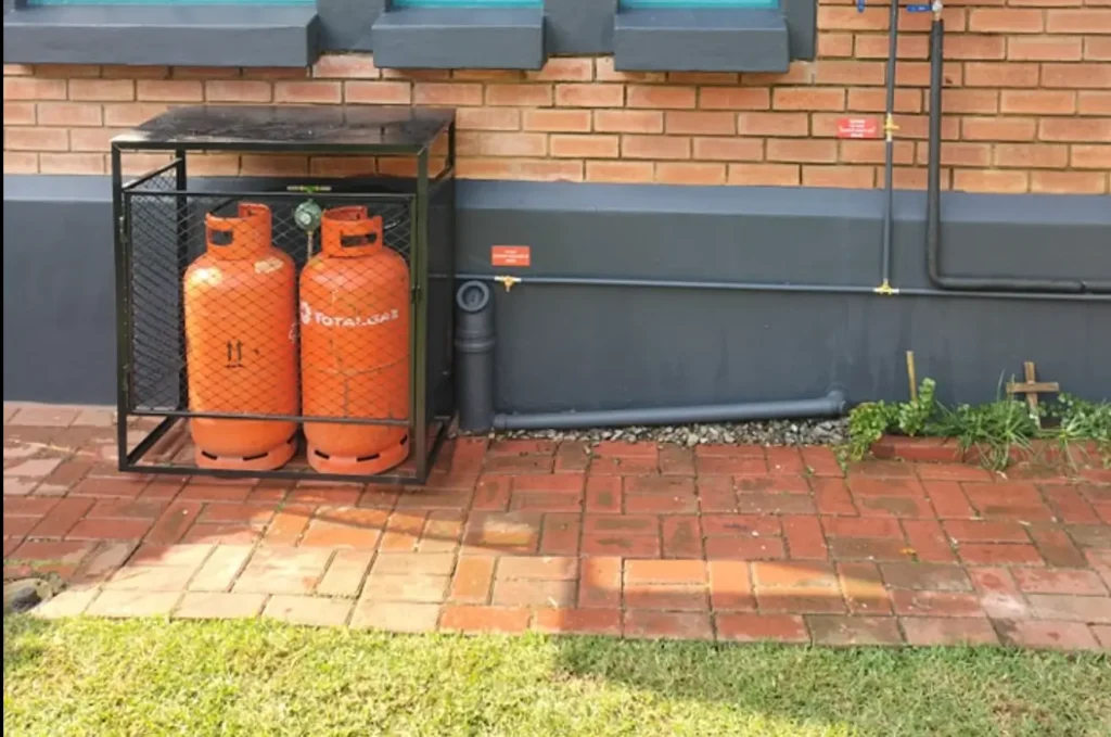 Gas installations showing outdoor LPG cylinders connected to a fixed gas line at a residential property